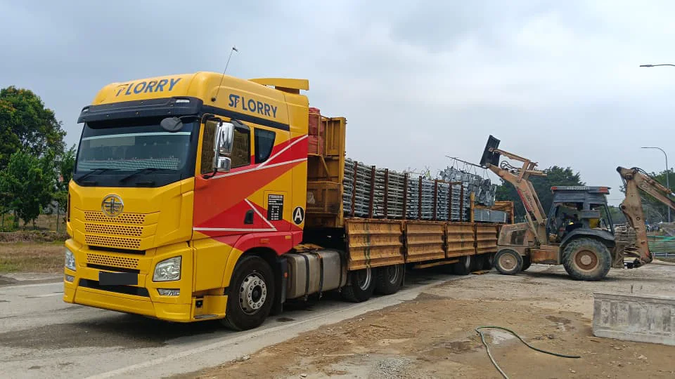 Treler terbuka SF Lorry bermuatan bahan pembinaan di tapak operasi Pulau Indah